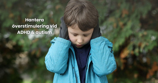 Pojke i blå jacka täcker öronen utomhus – symboliserar överstimulering vid ADHD och autism.