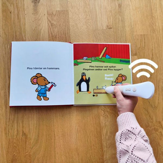 Hand som duttar Readioo läspenna mot boksidan i Byggare Pino, berättelsen spelas upp med ljud och röster.