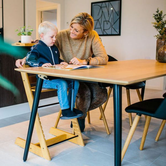 Förälder och barn sitter vid ett matbord där SWNX Mini är monterad för extra rörelse.