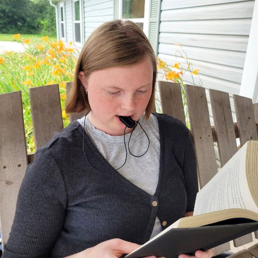 Flicka använder litet Tugghalsband MiniBite för diskret tuggstöd.