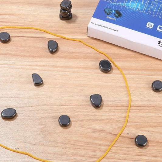 Närbild på spelplanen med magnetiska pjäser utspridda inom en gul ring på ett trägolv