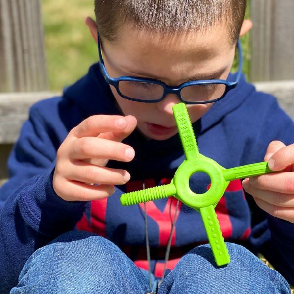 Pojke snurrar Tetra-Bite Fidget mellan händerna, använder den som handfidget.