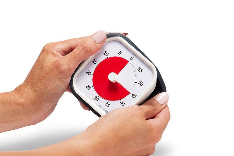 Händer håller Time Timer MOD för att visa dess bärbara och praktiska storlek.
