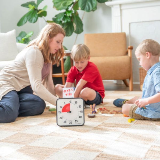 Familj leker tillsammans med tidshjälpmedel Time Timer mitt i rummet.