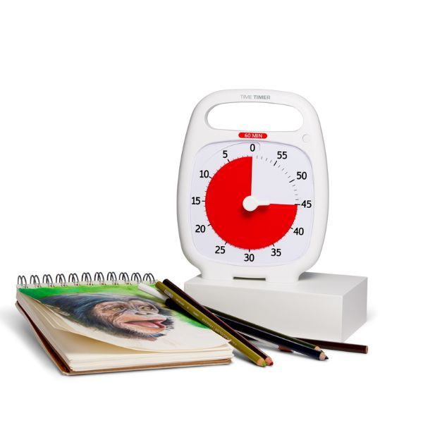 Time Timer Plus vit bredvid målarblock och färgpennor.
