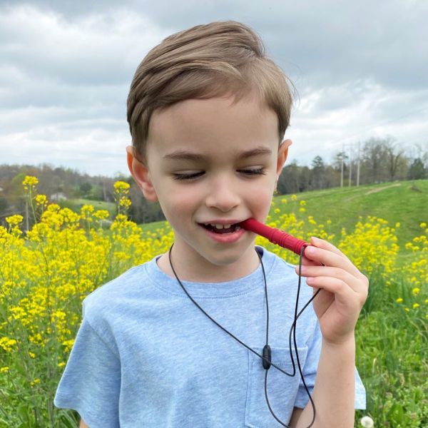 Barn använder Tugghalsband Bite Saber i ljusblå färg, ett ADHD-hjälpmedel för lugnare vardag