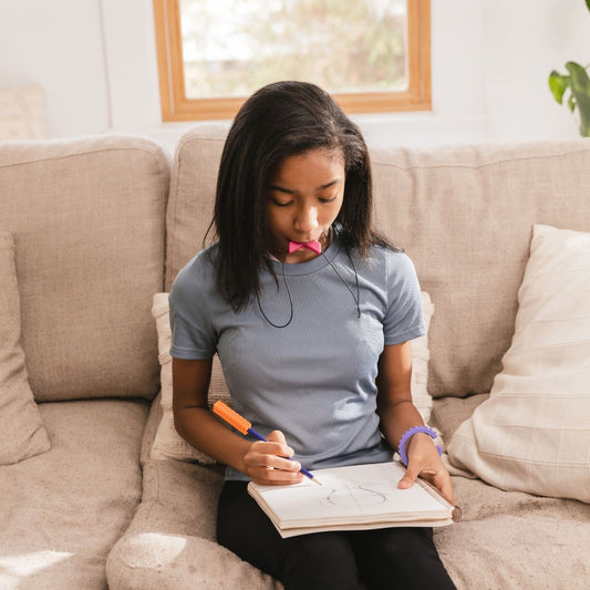 Flicka använder tugghalsband Chevron för ökad koncentration vid ADHD och autism