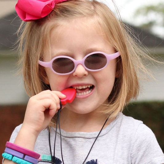 Barn tuggar på rött tugghalsband Pilspets från ARK