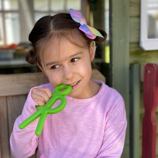 Barn tuggar på Tugghjälpmedel Buddy Bite i stickfigurform.