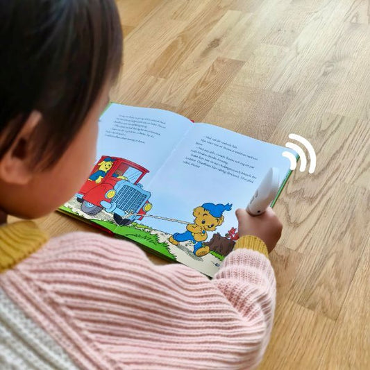 Barn som använder Readioo läspenna och lyssnar på den interaktiva barnboken Bamse och Brummelisa