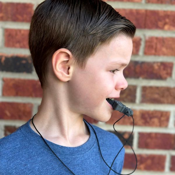 Barn använder svart RoboChew tugghalsband för ADHD & autism.