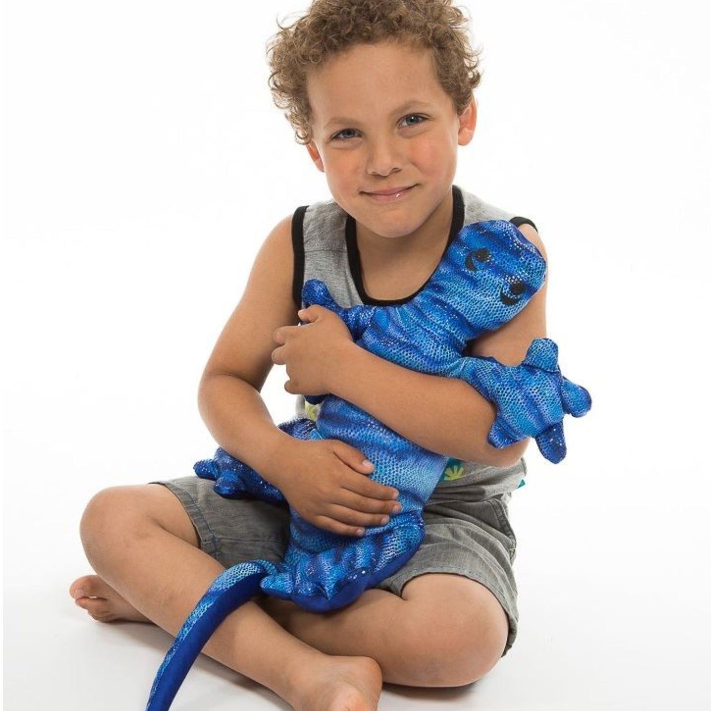 Barn kramar blå Manimo Tyngdödla, sensoriskt tyngddjur som ger trygg tyngd och kroppsnärvaro.