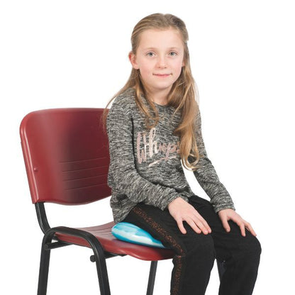 Barn som sitter på blå Bitty Bottom sittkudde, hjälpmedel för balans och koncentration