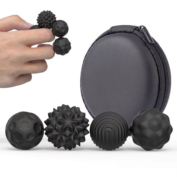 Hand håller svarta magnetiska fidgetkulor med texturer. 