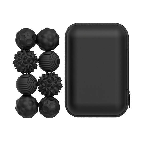 Åtta svarta fidgetbollar med olika texturer i ett svart rektangulärt förvaringsfodral.