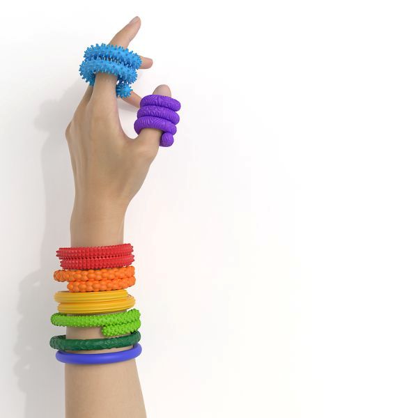 Hand som visar sensoriska fidgetstavar i olika färger och texturer för taktil stimulans