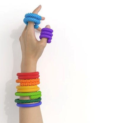 Hand som visar sensoriska fidgetstavar i olika färger och texturer för taktil stimulans