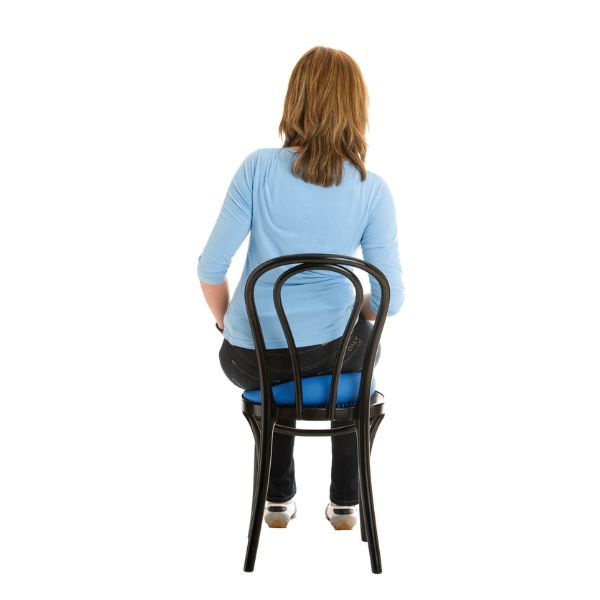 Person sitter bakifrån på blå sittkudde Happyback