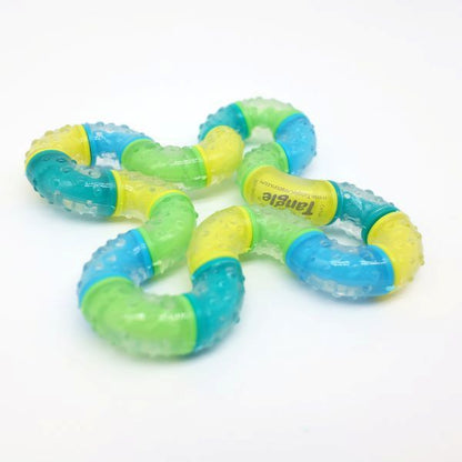 En flerfärgad Tangle BrainTools Think fidget leksak ligger platt på en vit bakgrund.