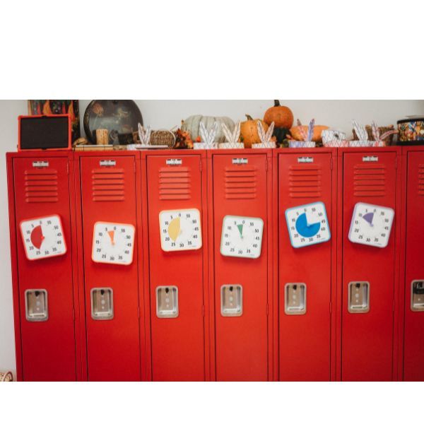 Flera Time Timer Medium uppsatta på röda skåp i skolmiljö som visuellt hjälpmedel.