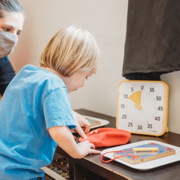 Barn arbetar med uppgifter vid ett bord medan en gul Time Timer Medium visar återstående tid.