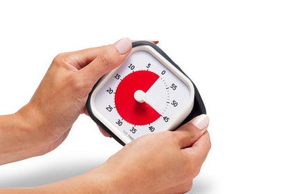 Händer håller Time Timer MOD för att visa dess bärbara och praktiska storlek.