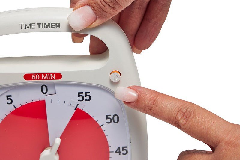Närbild på pause-knappen på Time Timer Plus i vitt, vilket illustrerar funktionaliteten för att pausa nedräkningen.